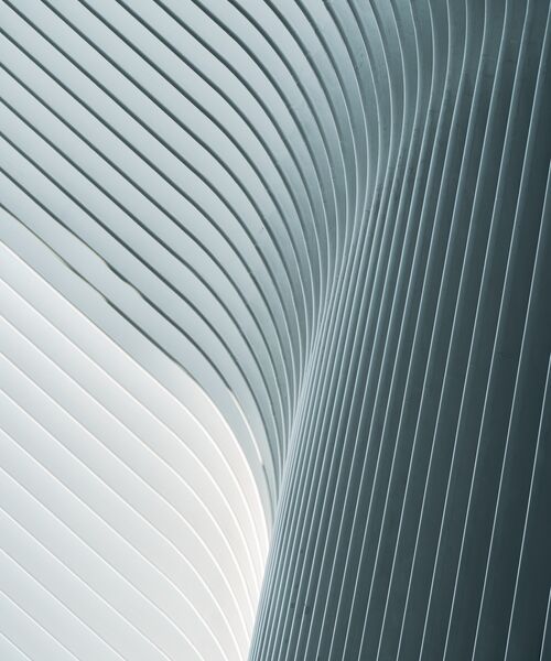 Moderne Architektur mit geschwungenen, parallel verlaufenden Linien in Grau und Weiß.