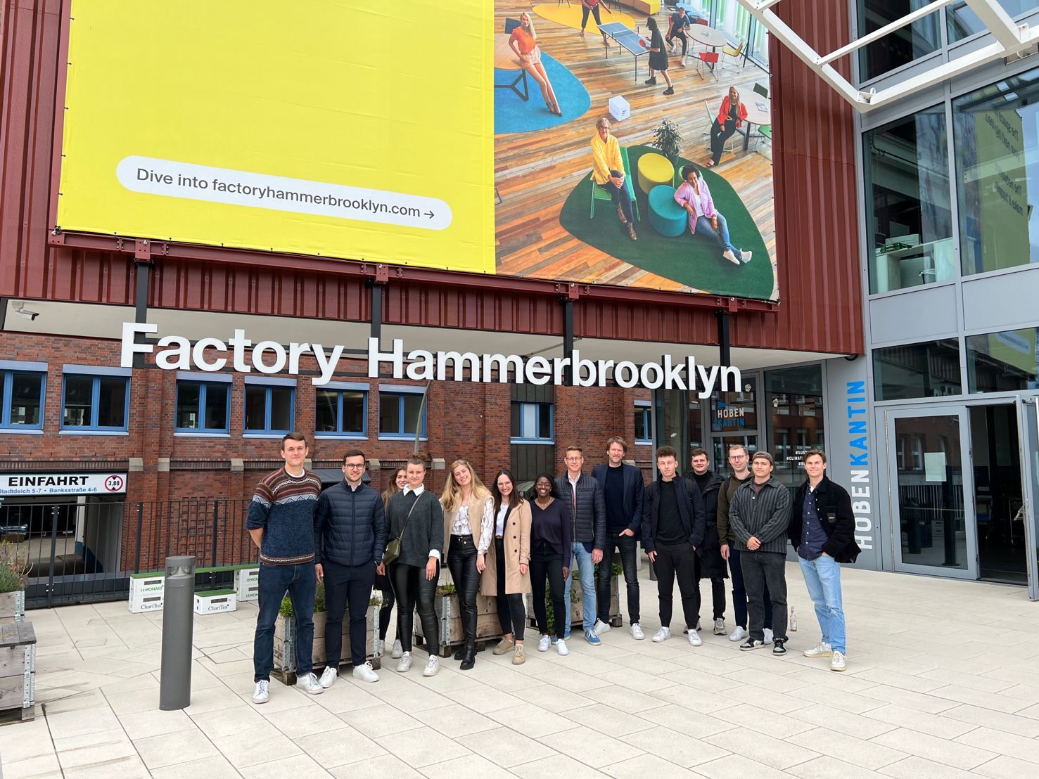 Gruppe junger Menschen vor dem Gebäude 'Factory Hammerbrooklyn'.