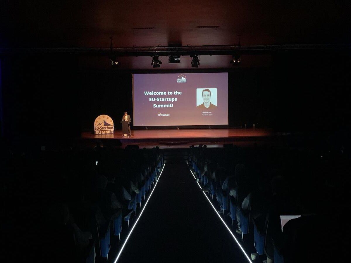 Großes Publikum verfolgt eine Präsentation beim EU-Startups Summit in einem abgedunkelten Auditorium.