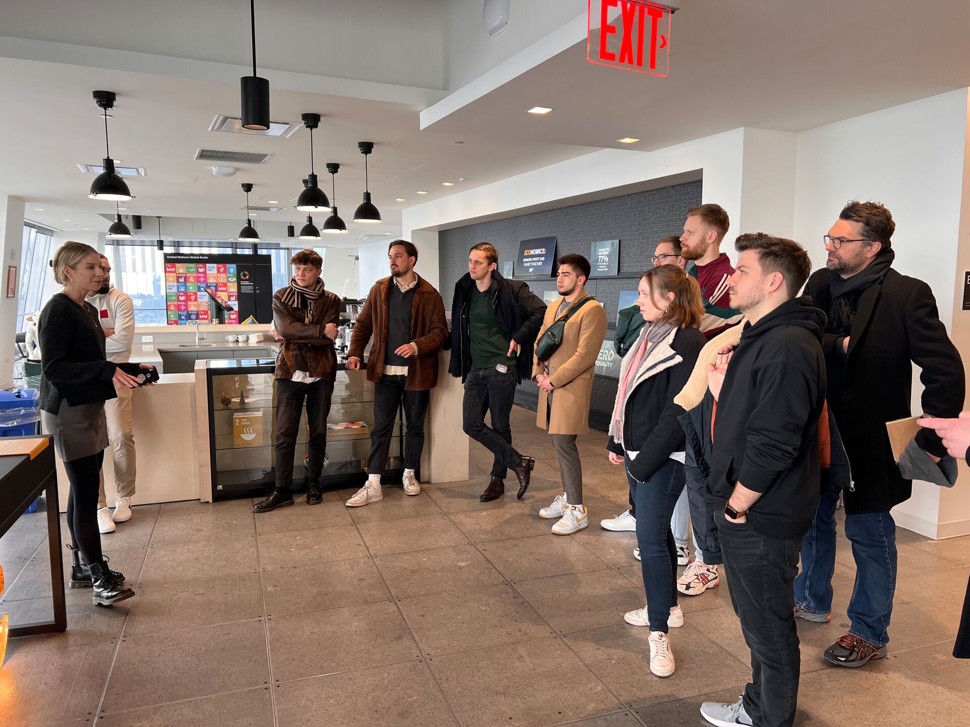 Studierende hören einer Präsentation in einem modernen Bürogebäude in New York aufmerksam zu.