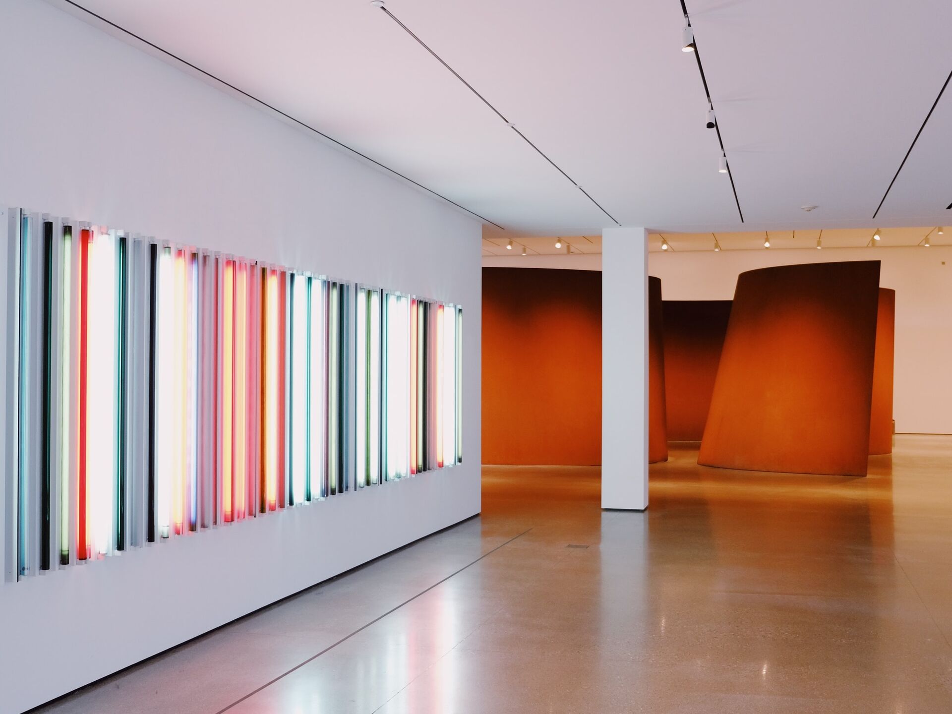 Moderne Kunstausstellung mit bunten Lichtinstallationen und großen Skulpturen.