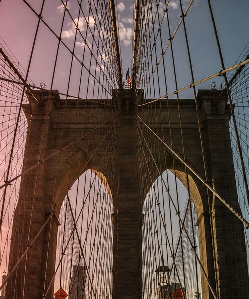 Blick auf die Seilkonstruktion und Bögen der Brooklyn Bridge bei Sonnenuntergang.