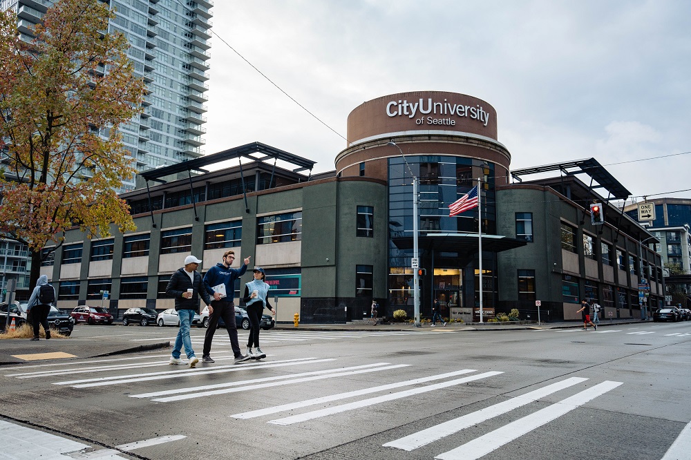 Straßenansicht der City University of Seattle mit Studierenden, die über einen Zebrastreifen gehen.